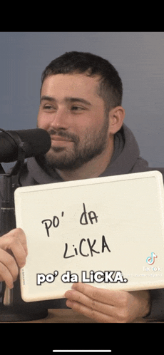 a man holding a sign that says po da licka