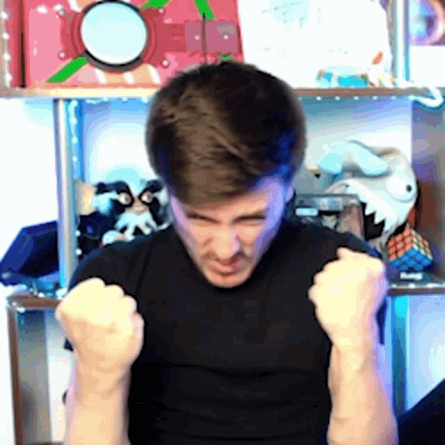 a man in a black shirt is making a fist with his hands in the air