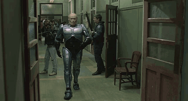 a man in a robot costume is walking down a hallway with other people