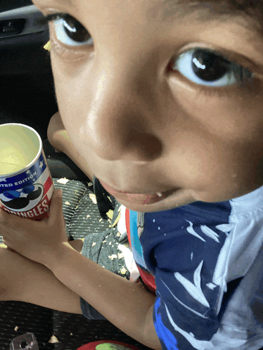 a young boy is holding a can of pringles limited edition