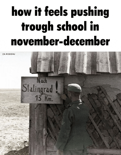 a black and white photo of a man pointing at a sign that says nach stalingrad 13 km.