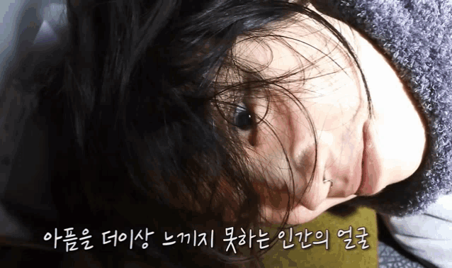 a close up of a woman 's face with korean writing behind her