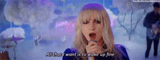 a woman is singing into a microphone and saying all that i want is to wake up fine .