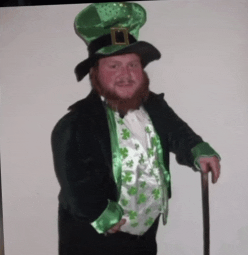 a man in a leprechaun costume is holding a cane and smiling