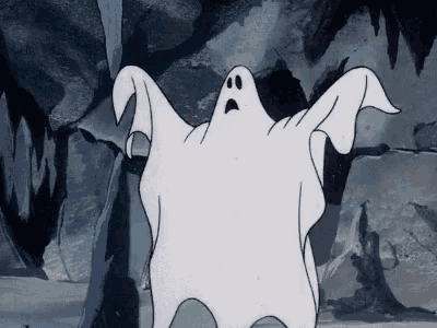 a cartoon ghost with a surprised look on his face is standing in front of a rock wall .