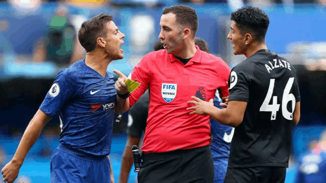 a referee wearing a red shirt that says fifa on it