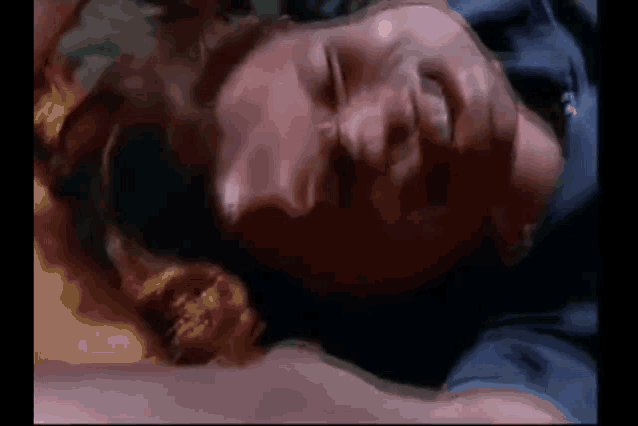 a close up of a person laying on their back with their eyes closed .