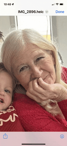 a phone screen shows a picture of an elderly woman and a baby