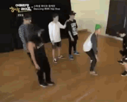 a group of young men are dancing in a room with a sign that says dancing with hip hop .
