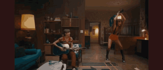 a woman playing a guitar in a living room with a lamp