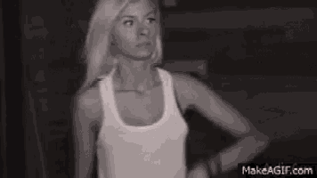 a black and white photo of a woman in a tank top .