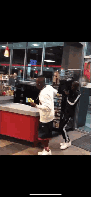 a man standing in front of a red counter with a sign that says ' coca cola ' on it