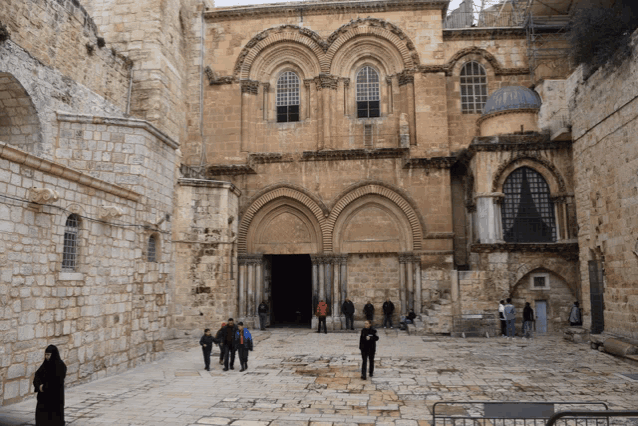 a group of people walking in front of a building