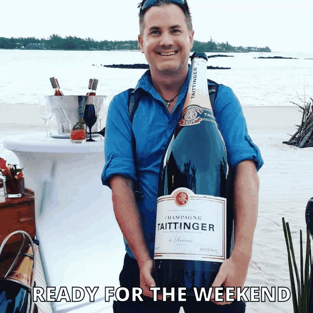 a man is holding a large bottle of champagne taittinger