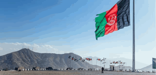 the flag of afghanistan is flying high in the wind