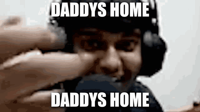 a man wearing headphones is taking a selfie with a caption that says `` daddys home daddys home ''