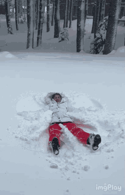 a person is laying in the snow with a gif play watermark