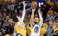 a basketball player is shooting a basketball while another player watches .