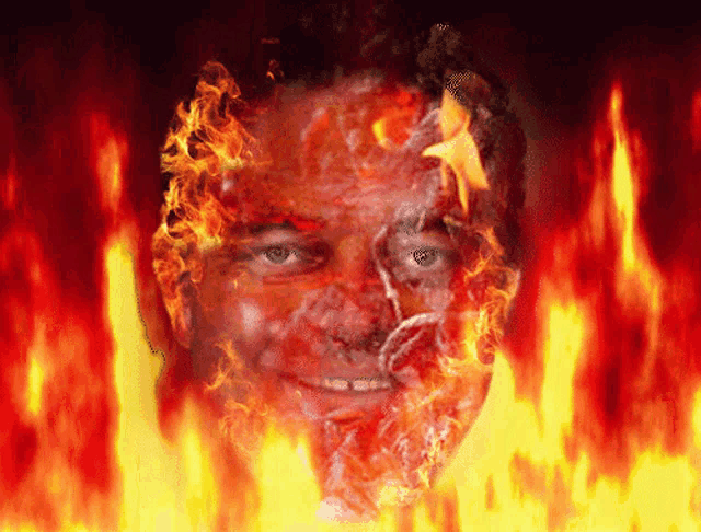 a man 's face is covered in flames with a star in the background