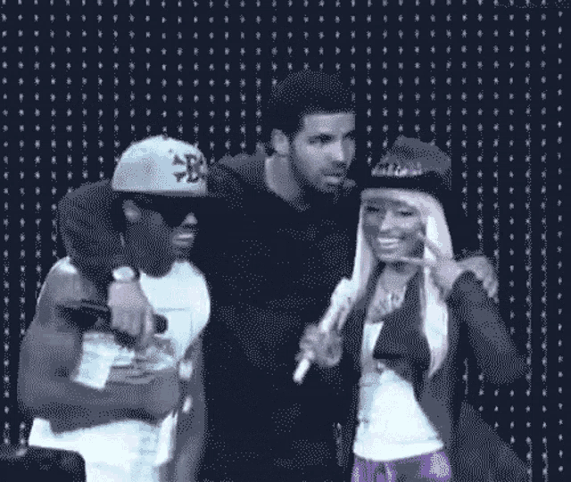 a woman singing into a microphone next to a man and a woman