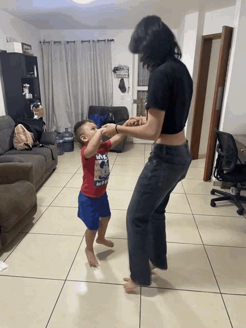 a little boy wearing a red shirt that says ' mickey mouse ' on it