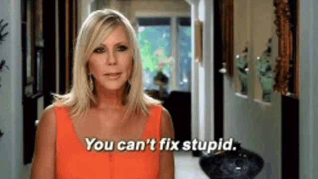 a woman is standing in a hallway and says you can 't fix stupid