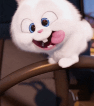 a white stuffed animal with blue eyes is sticking out its tongue