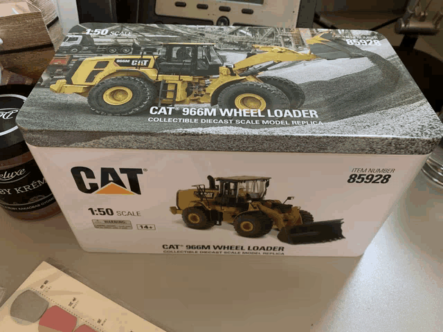 a cat 966m wheel loader is in a box on a table