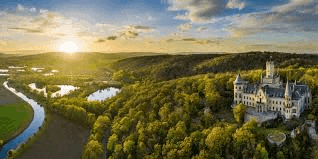 an aerial view of a castle on top of a hill surrounded by trees .