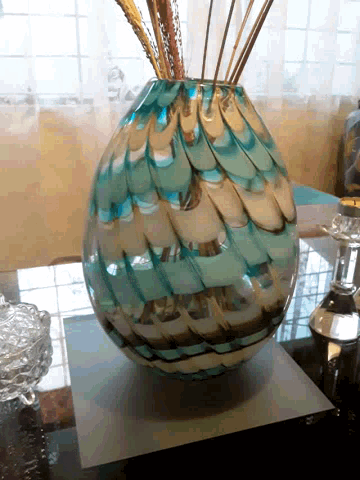 a blue and white vase sitting on a glass table