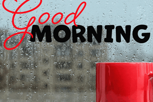 a red coffee mug sits in front of a window with the words good morning written on it