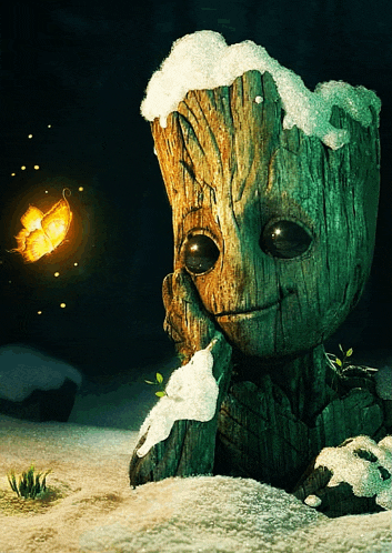 a tree stump with snow on it 's head and a butterfly in the background