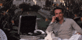a man is talking on a phone in front of a briefcase