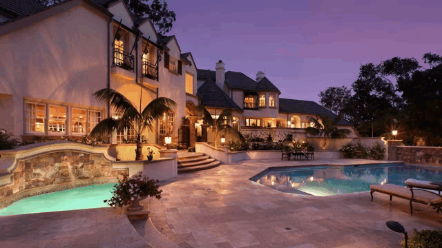 a large house with a swimming pool in front of it at night