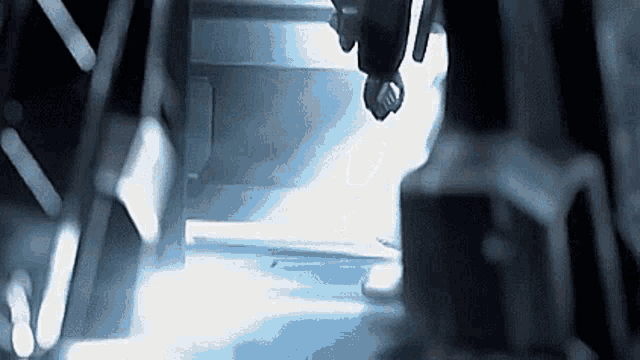 a person is walking down stairs in a dark room with a light shining on them .
