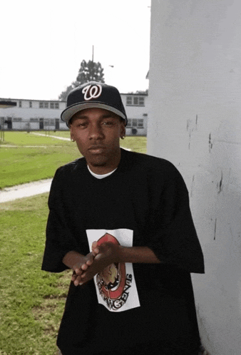 a man wearing a w hat and a stage shirt