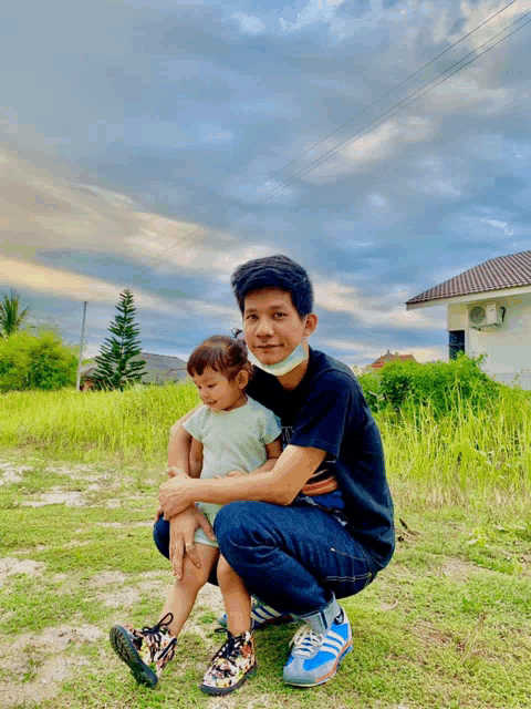 a man wearing a mask is kneeling down holding a child