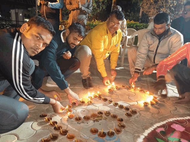 a group of men lighting candles in a circle on the ground