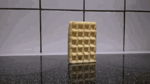 a waffle is sitting on a counter in front of a tile wall