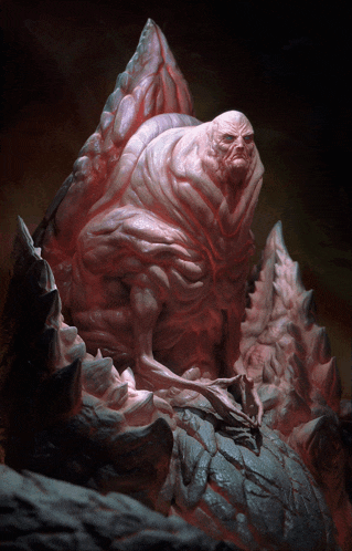 a statue of a monster is sitting on a rock in a dark room