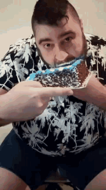 a man in a hawaiian shirt is eating a slice of cake .