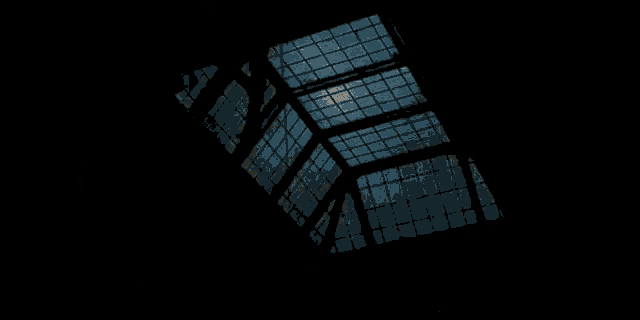 looking up at the ceiling of a building with a blue sky behind it .