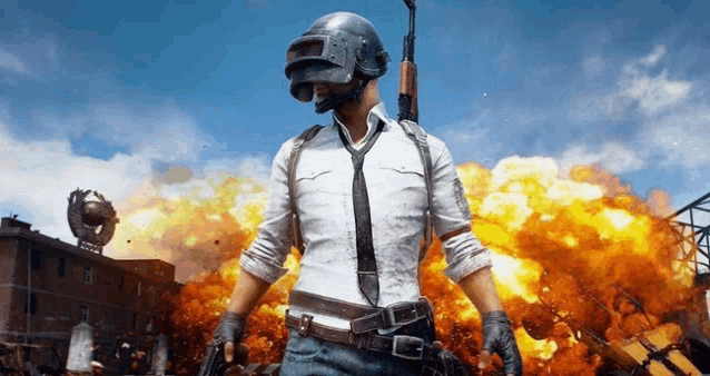 a man wearing a helmet and tie is standing in front of an explosion .