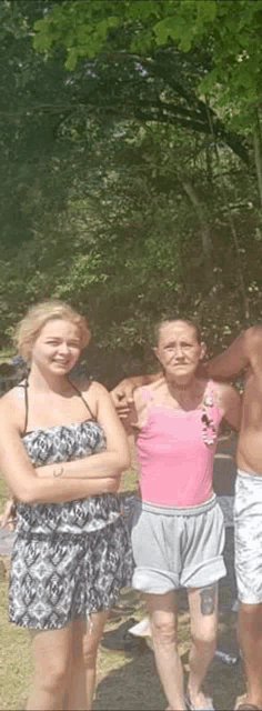 a group of people are posing for a picture in the park .