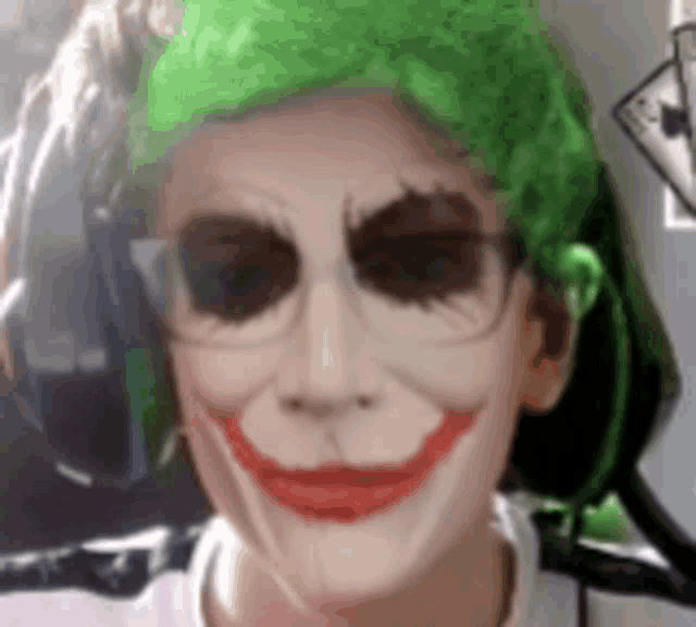 a person wearing a joker mask and glasses is smiling .