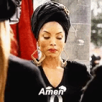 a woman wearing a turban and earrings is standing next to a man .