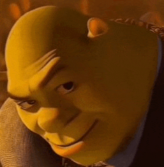 shrek from shrek is wearing a suit and tie and smiling at the camera .