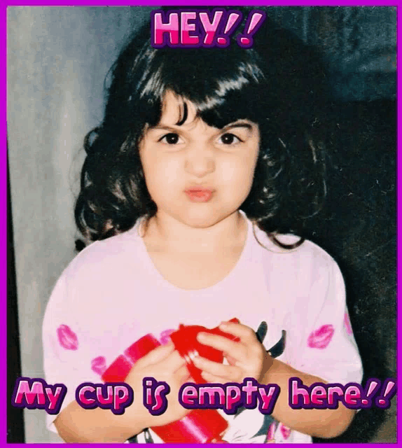 a little girl is holding a red cup with the words hey my cup is empty here