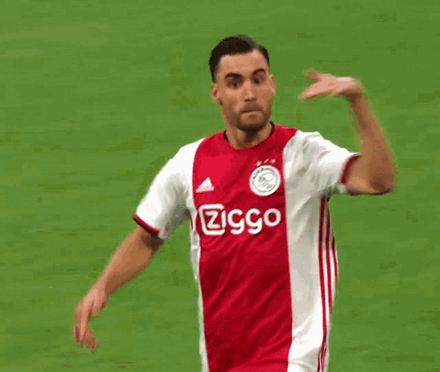 soccer player wearing a red and white jersey that says ziggo on it