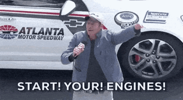 a man stands in front of a atlanta motor speedway car
